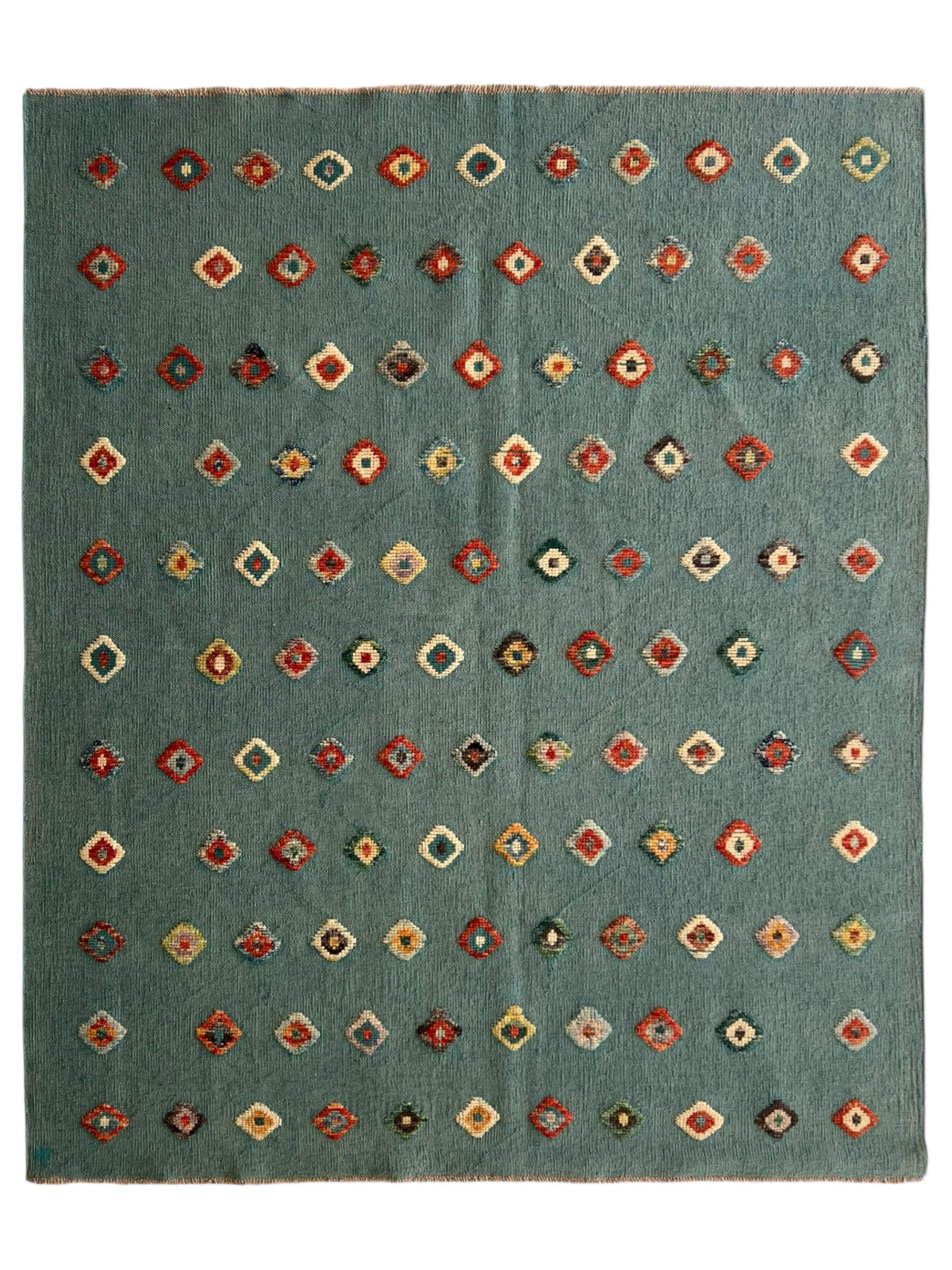 Geometric patterned rug with multicolor design on a teal background