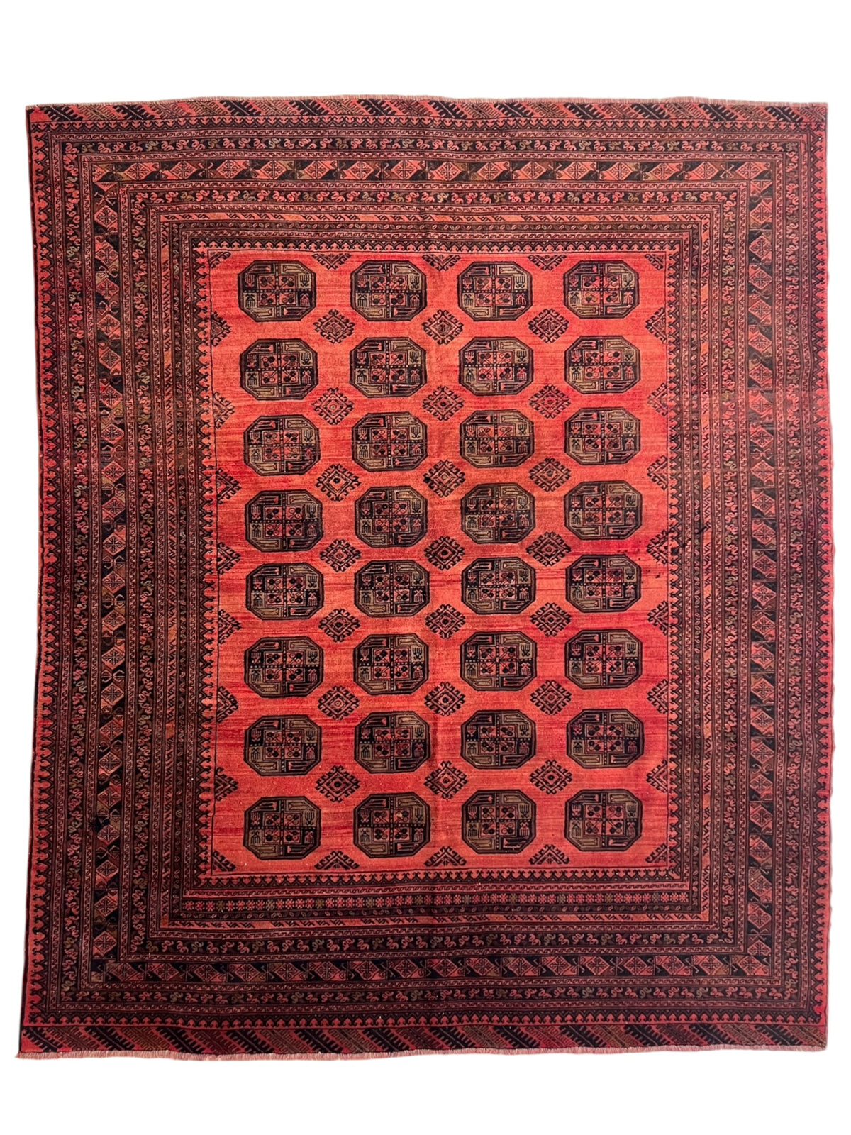 Red and black patterned rug on a white background