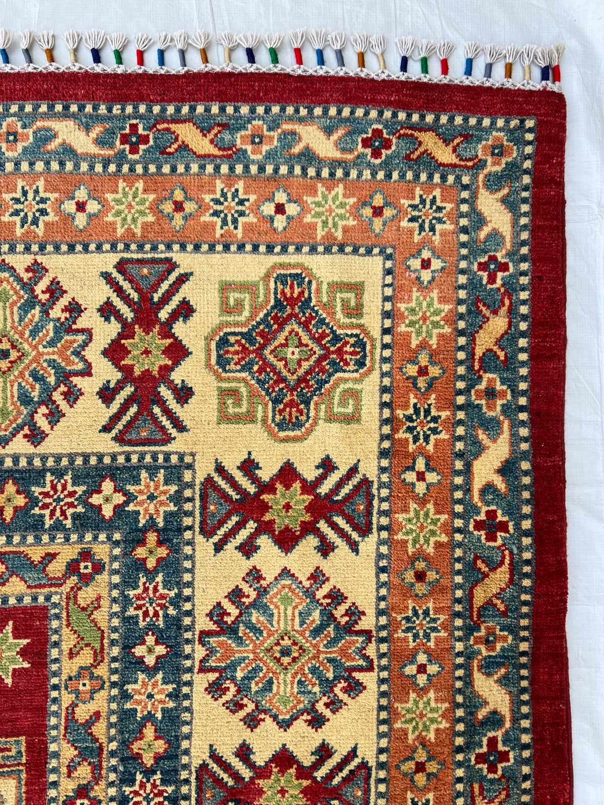 Kazak Rug 9x12 | Red, Ivory & Blue | hand-knotted wool | close-up of pile and border