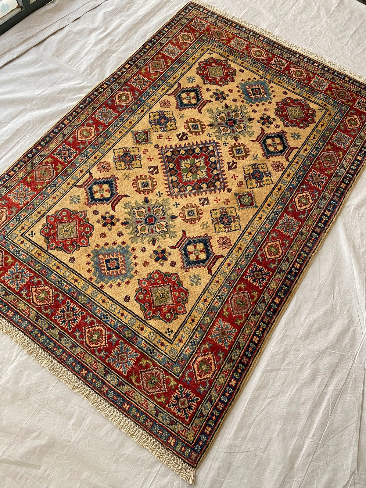 Kazak Rug 4x6 | Ivory, Red & Navy | hand-knotted wool | angled view