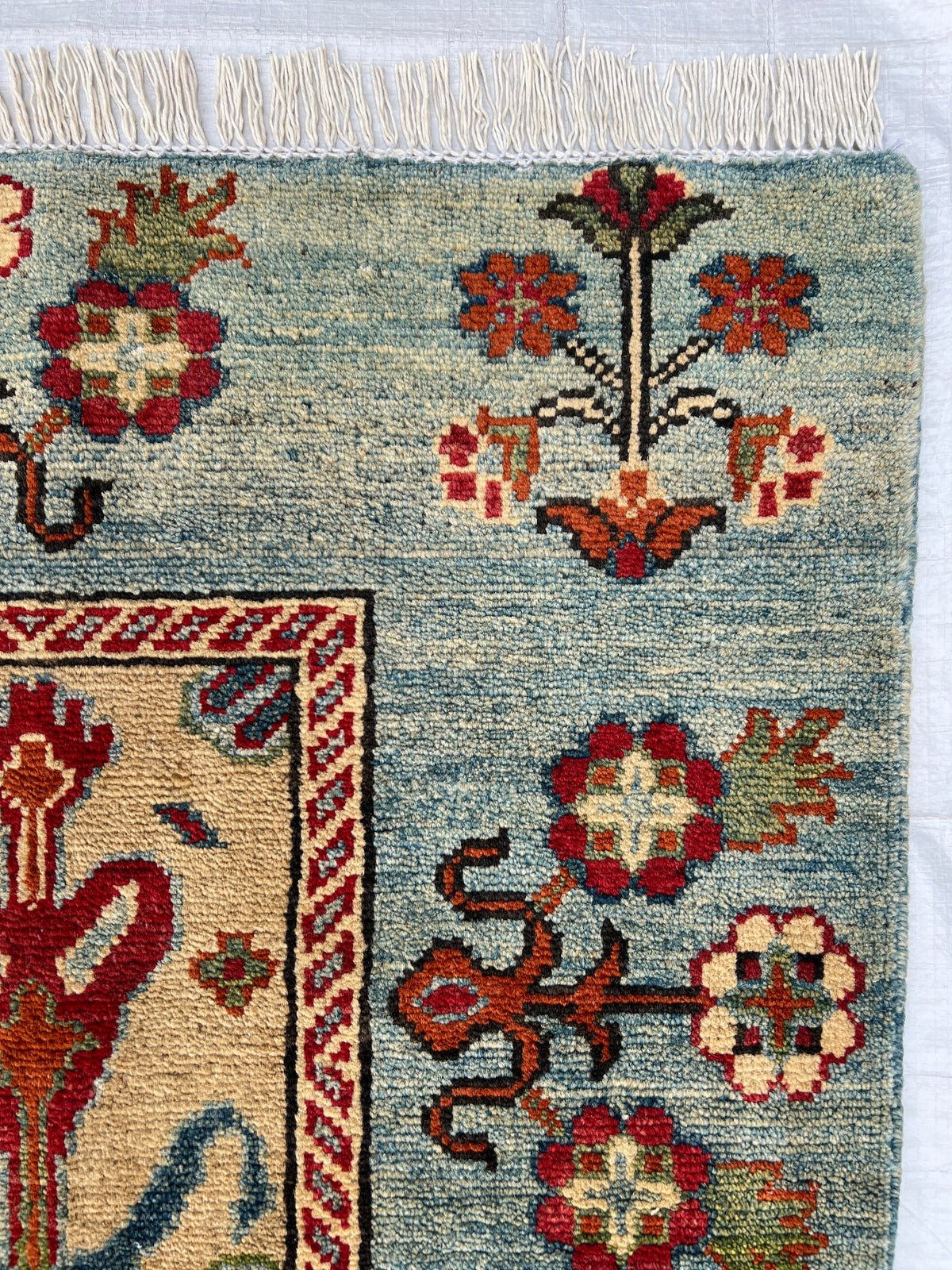Kazak Rug 5x6 | Light Blue, Red & Gold | hand-knotted wool | close-up of pile and border