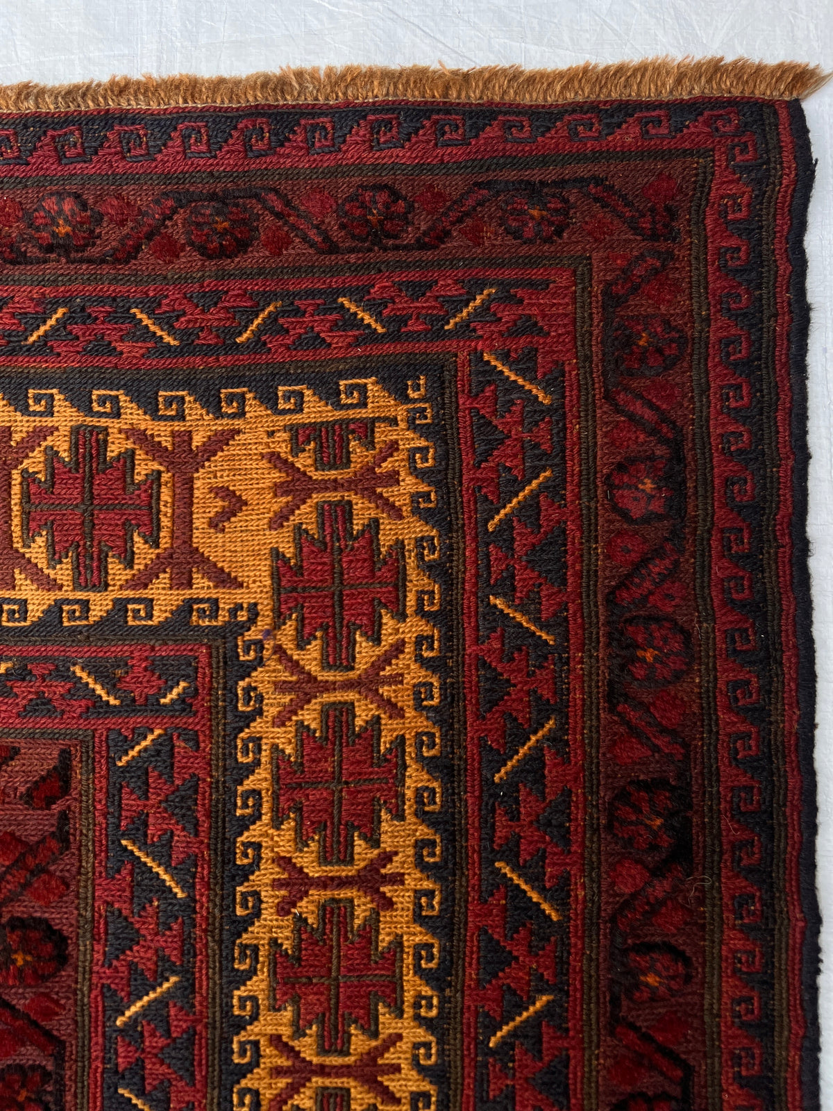 Baluch Rug 6x9 | Black, Gold & Burgundy | hand-knotted wool | close-up of pile and border