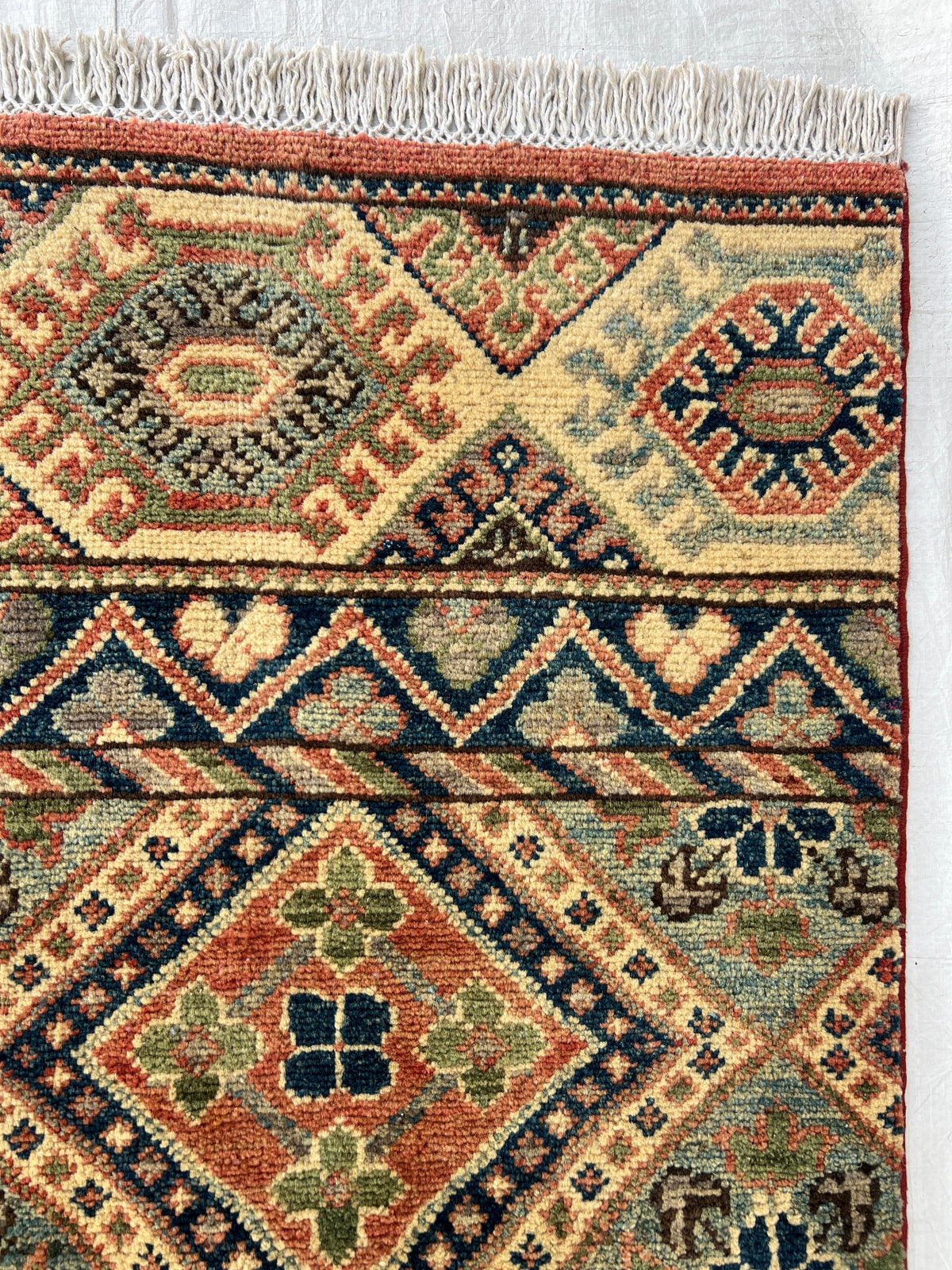 Kazak Rug 9x12 | Ivory, Red & Navy | hand-knotted wool | close-up of pile and border