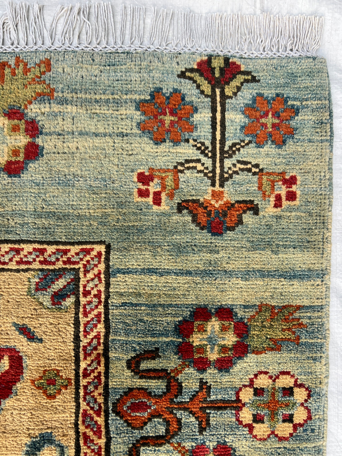 Kazak Rug 5x6 | Light Blue, Red & Gold | hand-knotted wool | close-up of pile and border