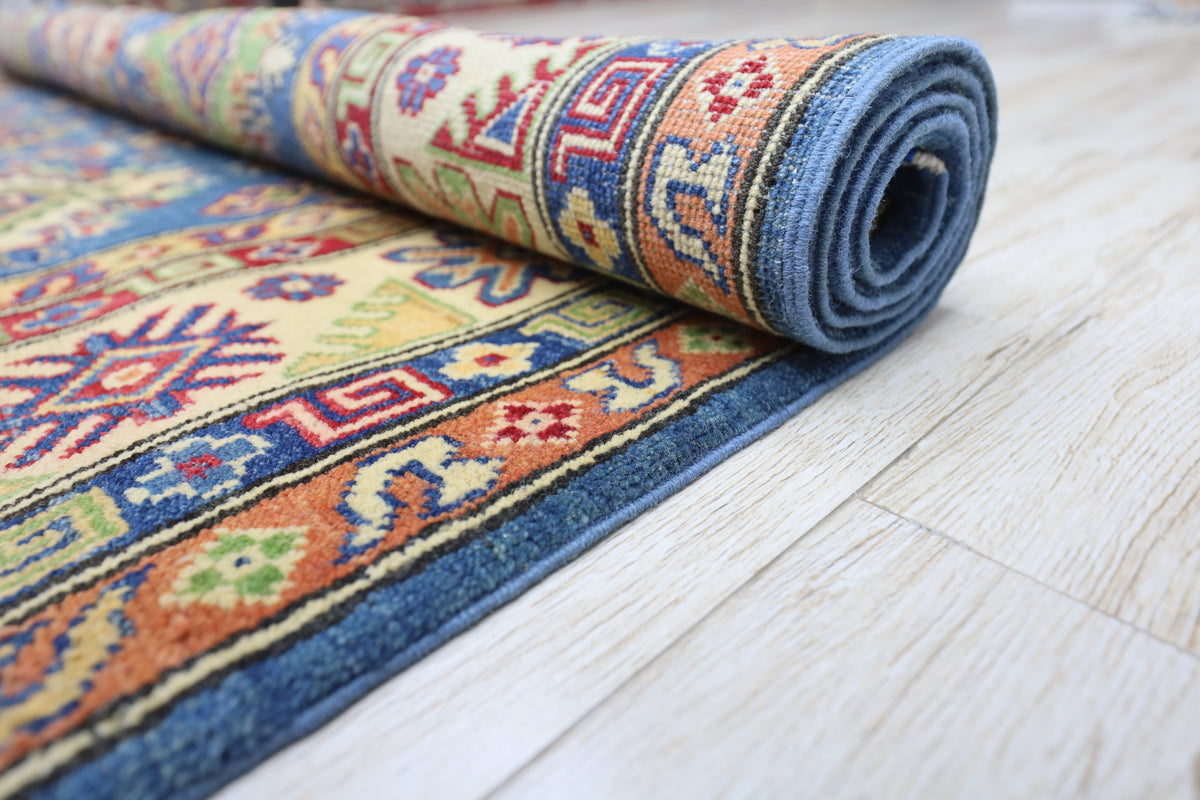 Rolled-up colorful patterned rug on a wooden floor